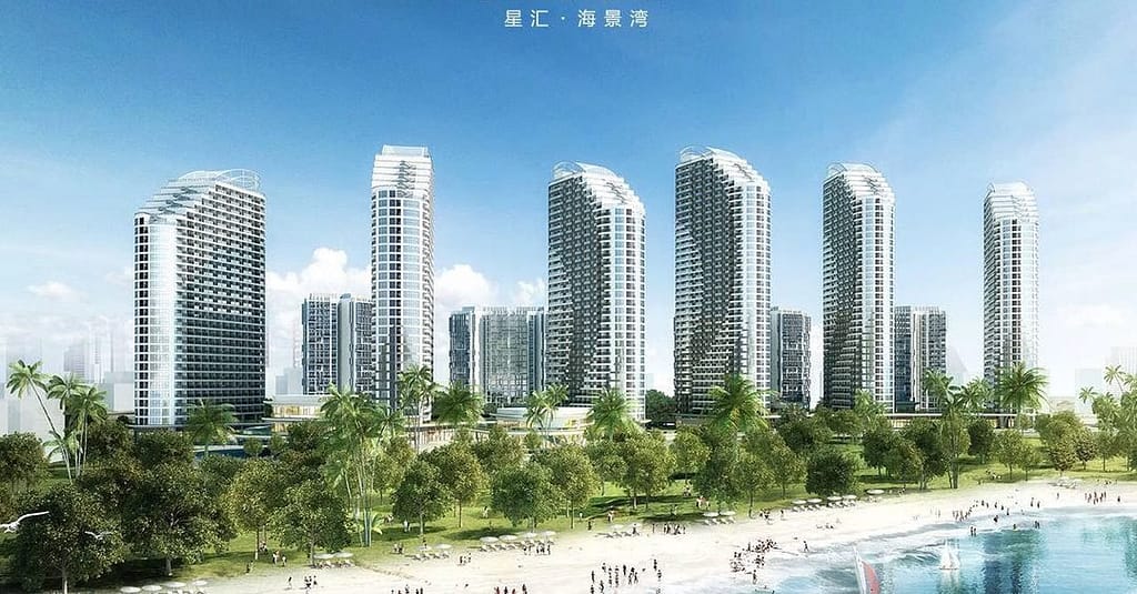 A row of modern high-rise buildings with curved roofs stands near the sandy beach of Star Bay Sihanoukville, lined with palm trees under a clear blue sky. Chinese characters are visible at the top of the image.