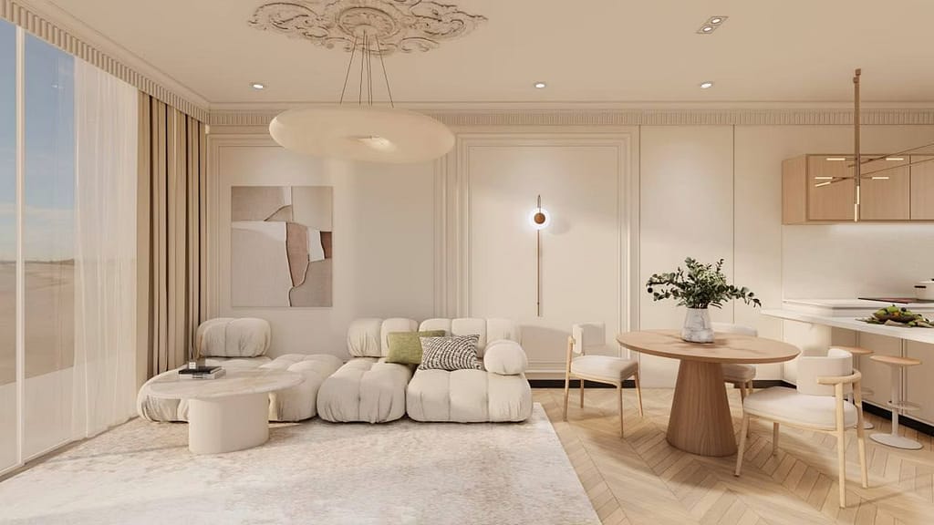 Bright, modern living room with cream-colored sofa, round coffee table, abstract wall art, and a dining area with a wooden table and chairs. Large windows let in natural light; neutral tones and minimalistic decor create a cozy atmosphere.